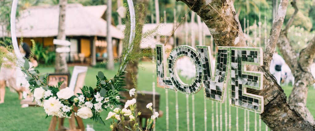 Mirrored LOVE letters and white florals styling the garden reception at Jeeva Santai Villas, Lombok