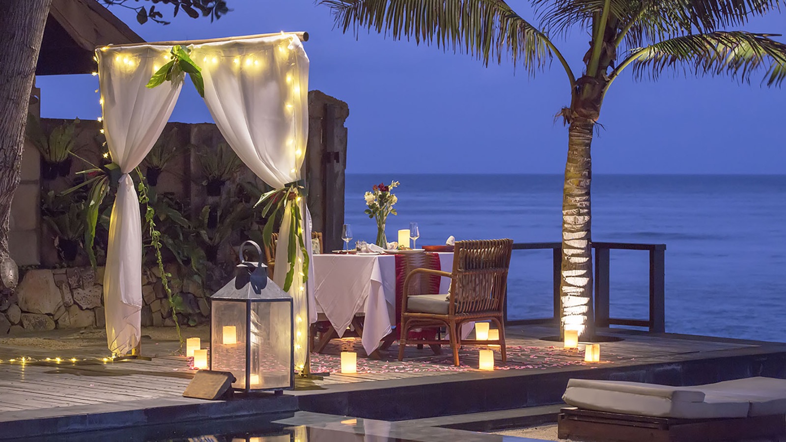 Candlelit private dinner under a draped canopy on the deck above the sea at dusk, Jeeva Santai Villas, Lombok