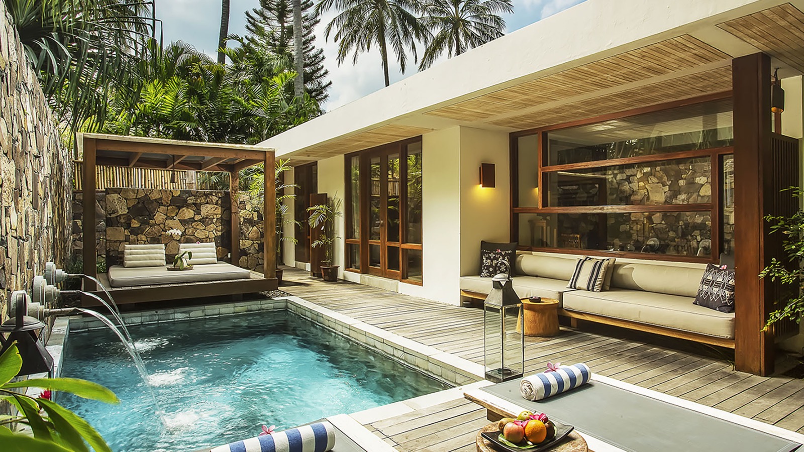 Pool villa with a plunge pool, daybed and stone wall at Jeeva Santai Villas on Mangsit Beach, Lombok