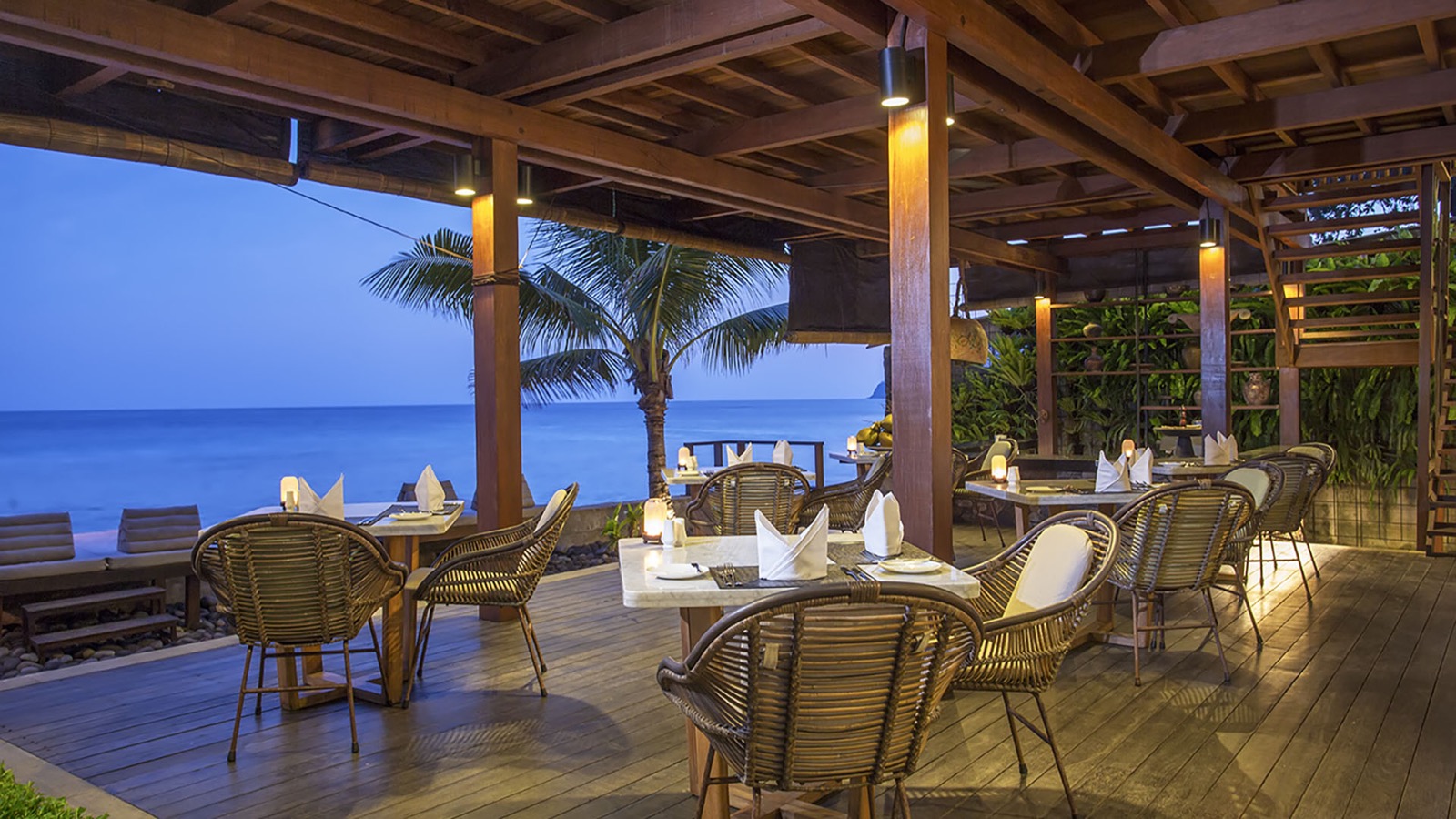 Pearl's restaurant deck set for dinner facing the water at dusk, Jeeva Santai Villas, Mangsit, Lombok