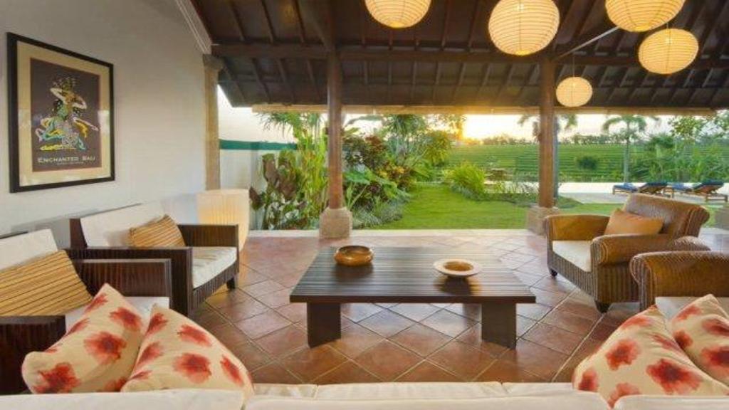 Living pavilion at The Junno Villa opening onto the surrounding rice fields