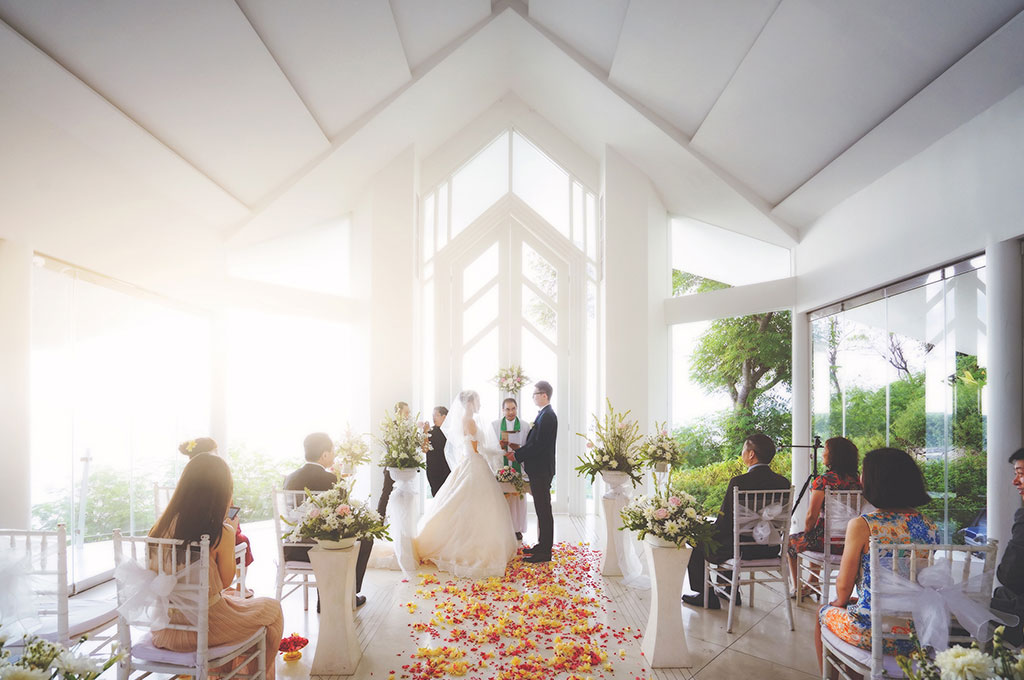 White glass wedding pavilion with a petal aisle and floral pedestals at Katamaran Resort Lombok