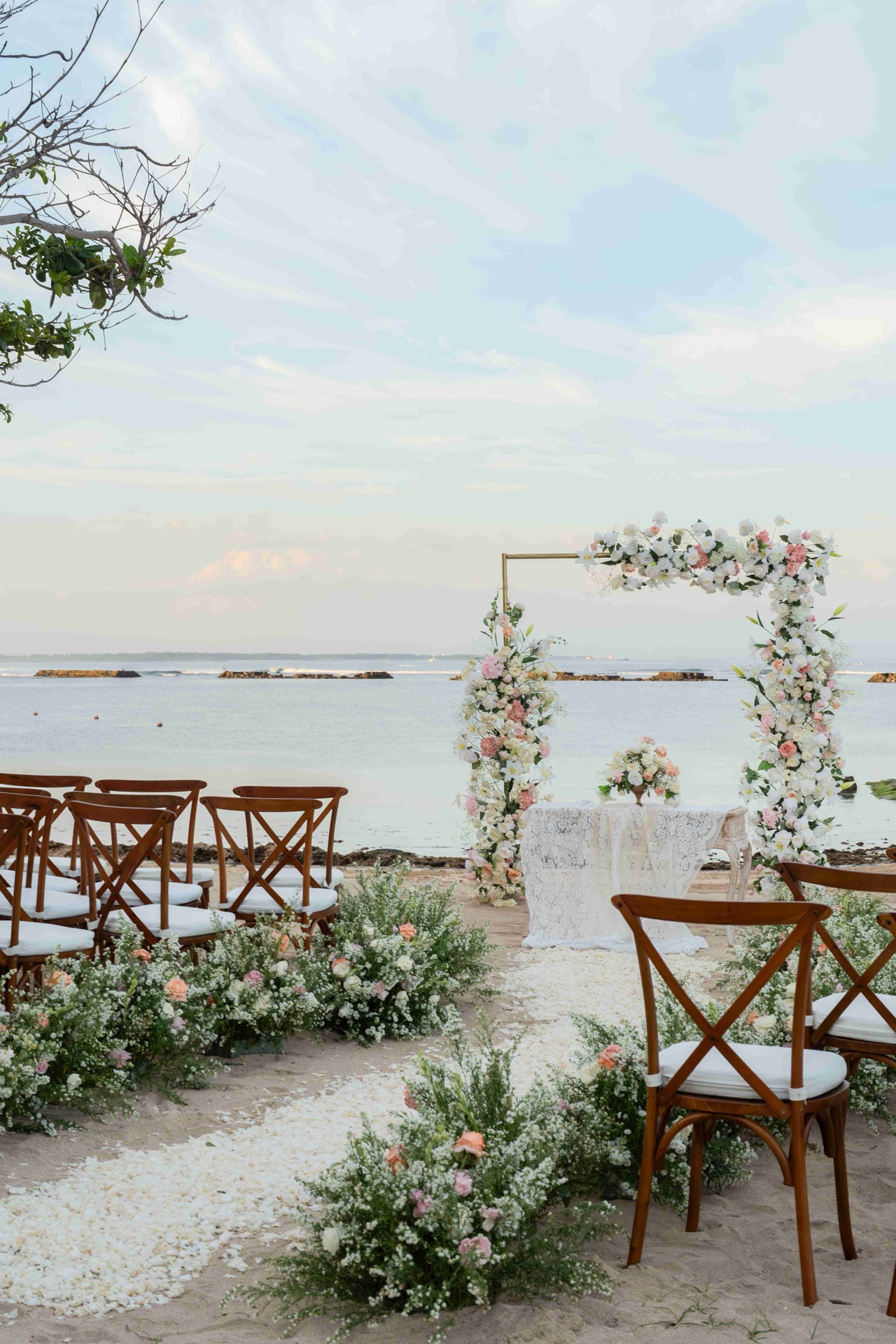 Beach ceremony decor in soft pink tones on the sand at Kayumanis Nusa Dua