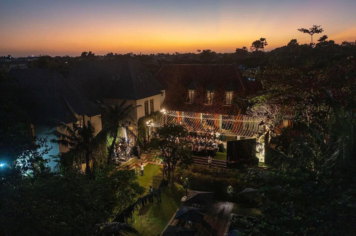 Sunset aerial of The Kemilau Villa Umalas showing the red-tiled European villa, garden reception and pool in Umalas, Canggu
