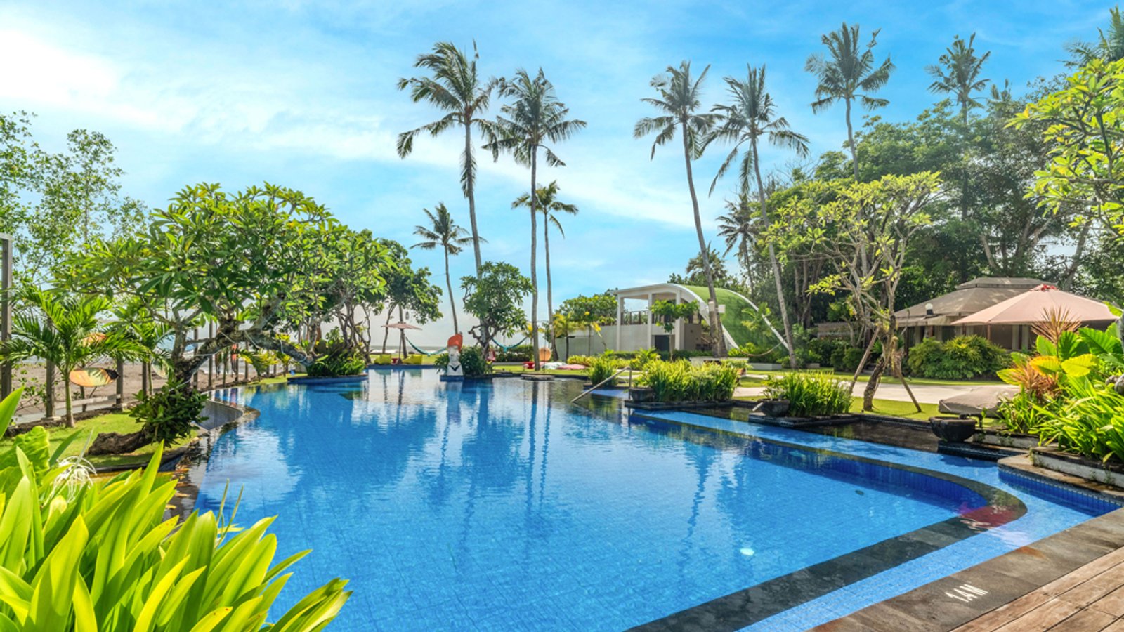 Pool and lawn area facing the sea at Kiss Bali Beach Residence, Cemagi