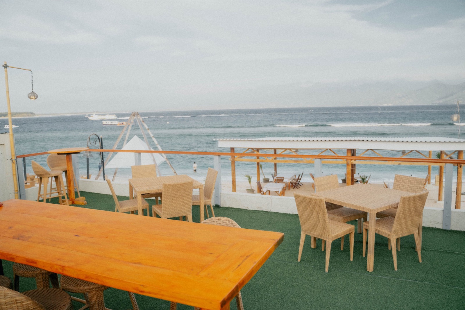 Rooftop deck with dining tables looking over the beach and the strait towards Lombok at Ko-Ko-Mo Gili T Resort, Gili Trawangan