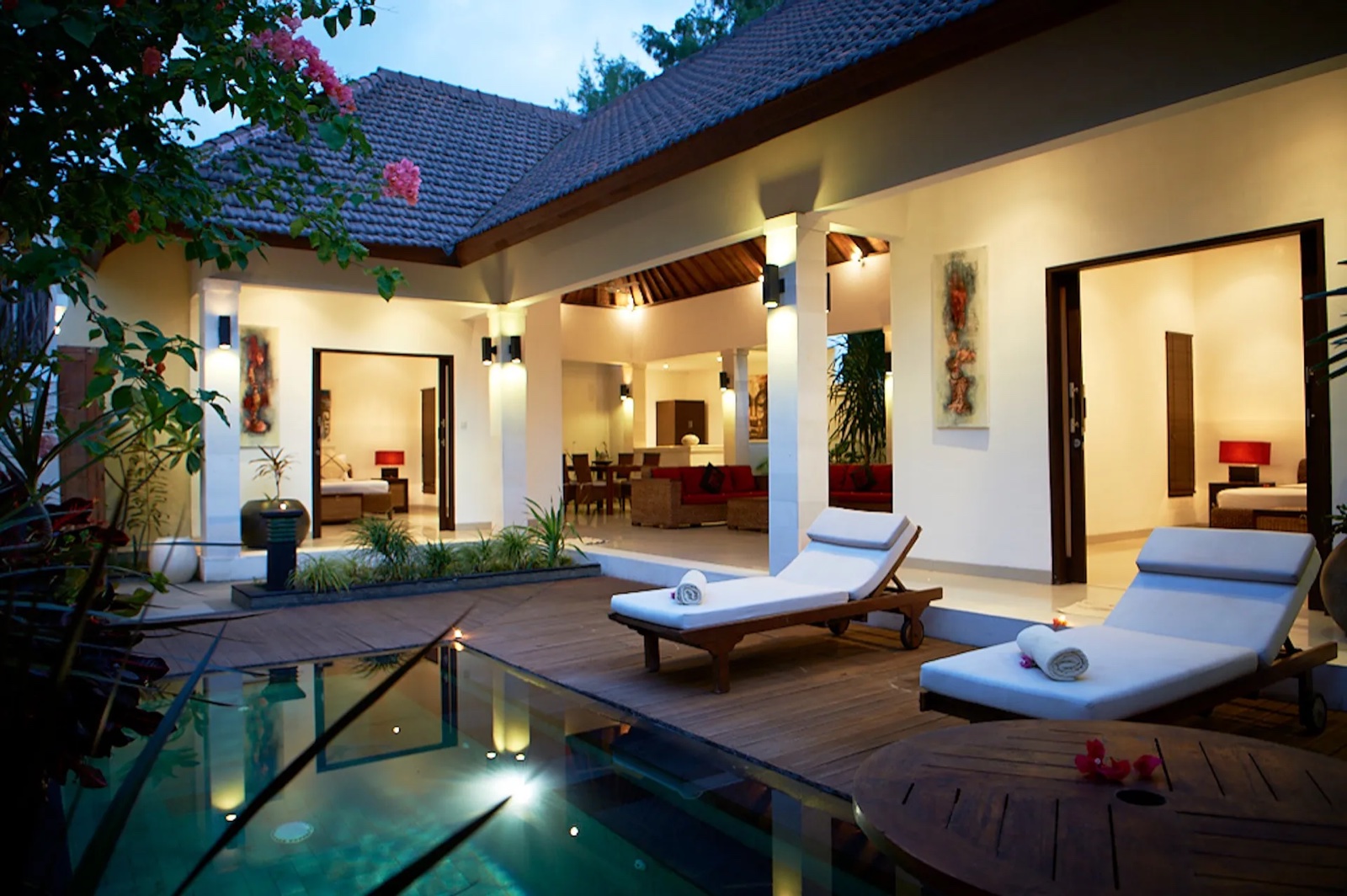 Private-pool villa lit at dusk with sun loungers on the timber deck at Ko-Ko-Mo Gili T Resort, Gili Trawangan
