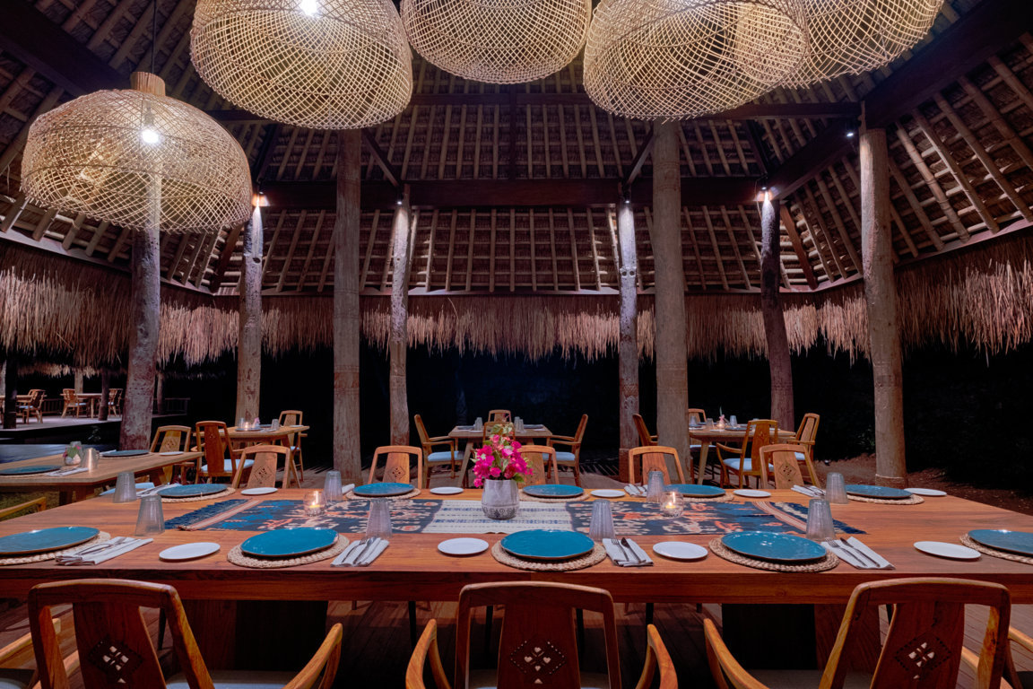 Bakosawu restaurant interior with woven pendant lights and a long ikat-dressed table at Lelewatu Resort Sumba, Sumba