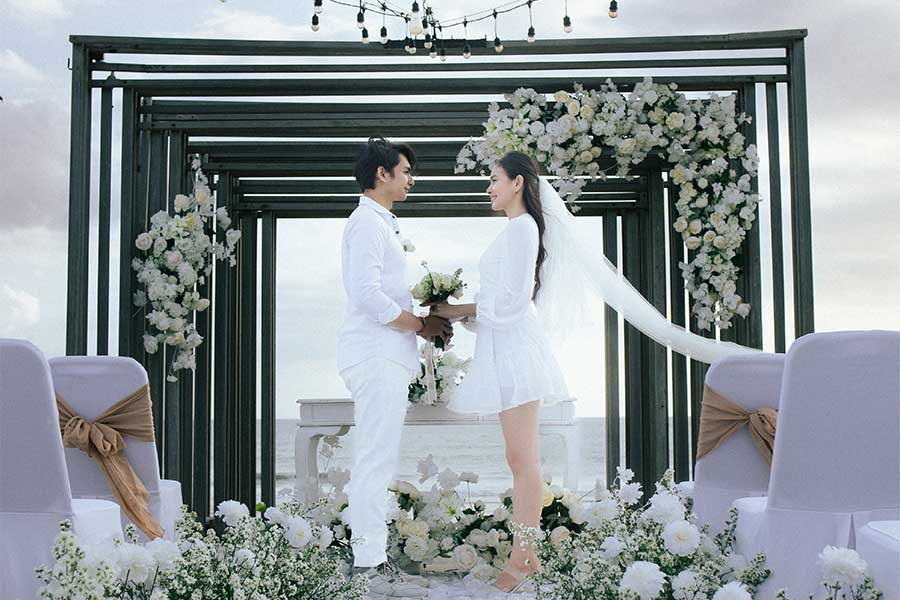 Pool wedding ceremony setup with decorated arch and ocean backdrop at Lv8 Resort Hotel, Canggu