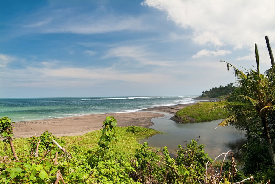 The Seseh coastline beach in front of Mahatma House, with a river mouth meeting the sand