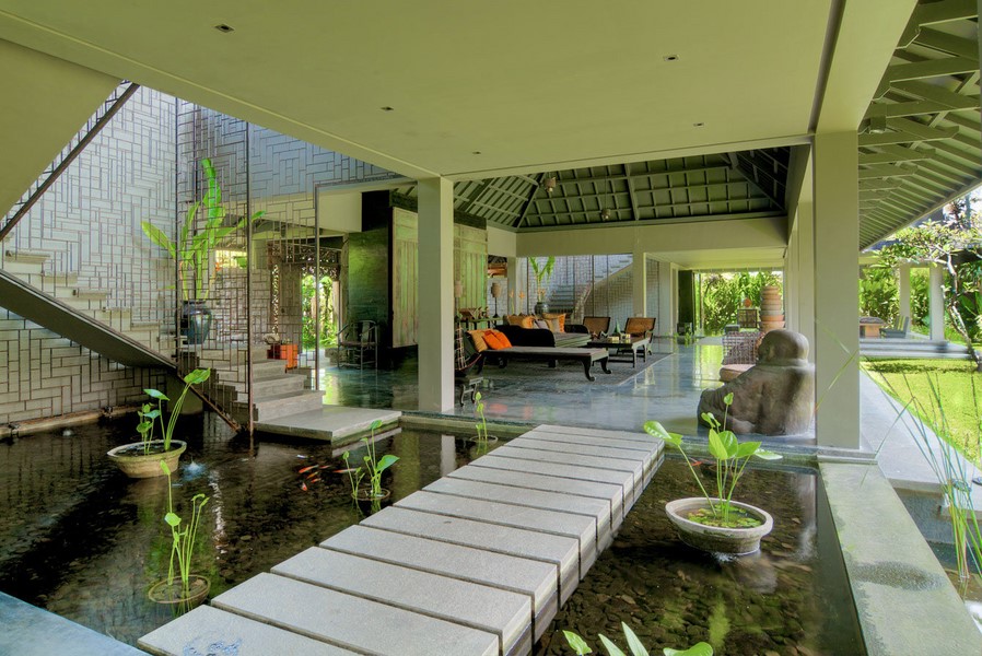 Open-plan lounge at Mahatma House built over a koi pond, with a stepping-stone walkway