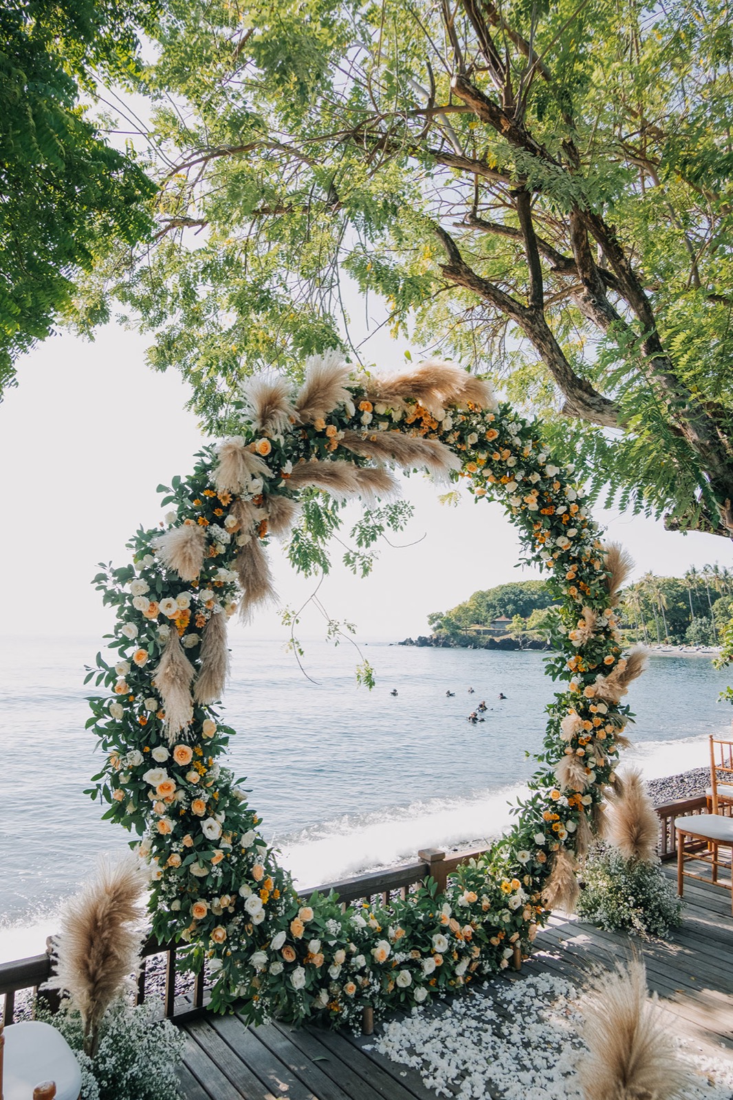 Circular floral and pampas ceremony arch on the seaside deck above the shore at Mimpi Resort Tulamben in northeast Bali