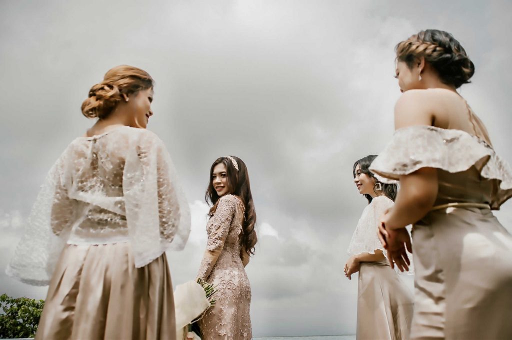 Bride in a beaded kebaya laughing with her bridesmaids under grey highland cloud at Munduk Heaven Luxury Villas, Munduk, Bali