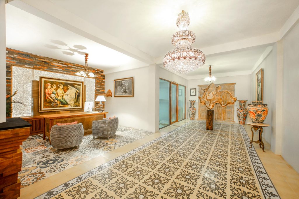 Reception hall with a crystal chandelier and patterned cement tiles at Munduk Heaven Luxury Villas, Munduk, north Bali
