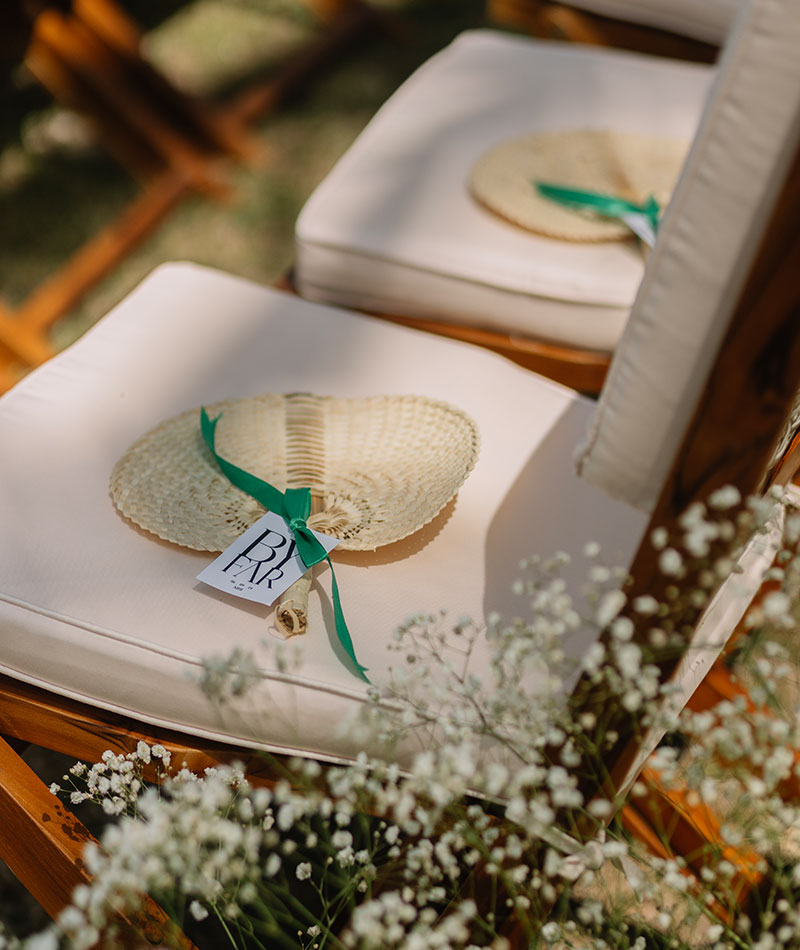 Woven palm fans tied with green ribbon left on ceremony chairs at NIHI Sumba, Sumba