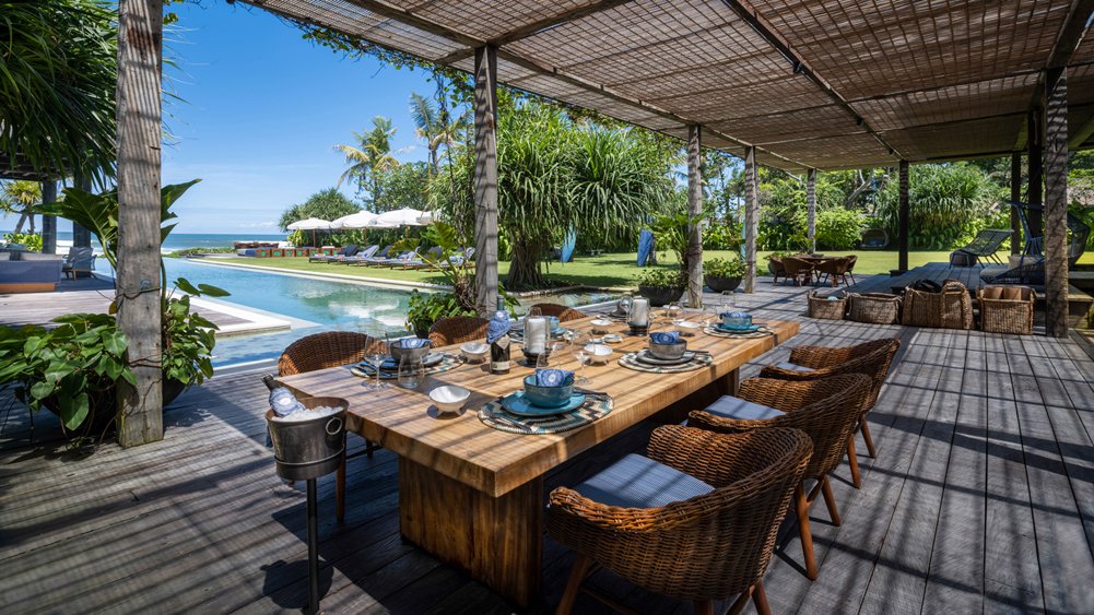 Alfresco dining set on the lawn at Noku Beach House with the ocean beyond