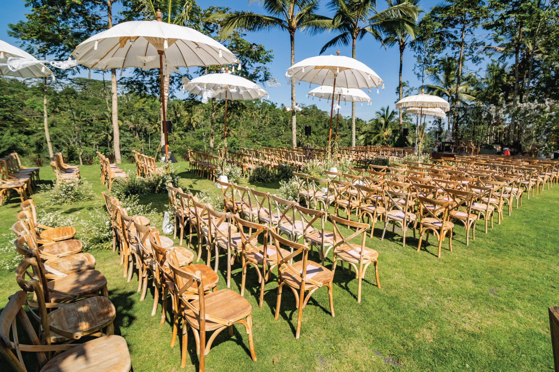 The wedding lawn at Padma Resort Ubud set for a ceremony with Balinese umbrellas and the Payangan forest valley beyond
