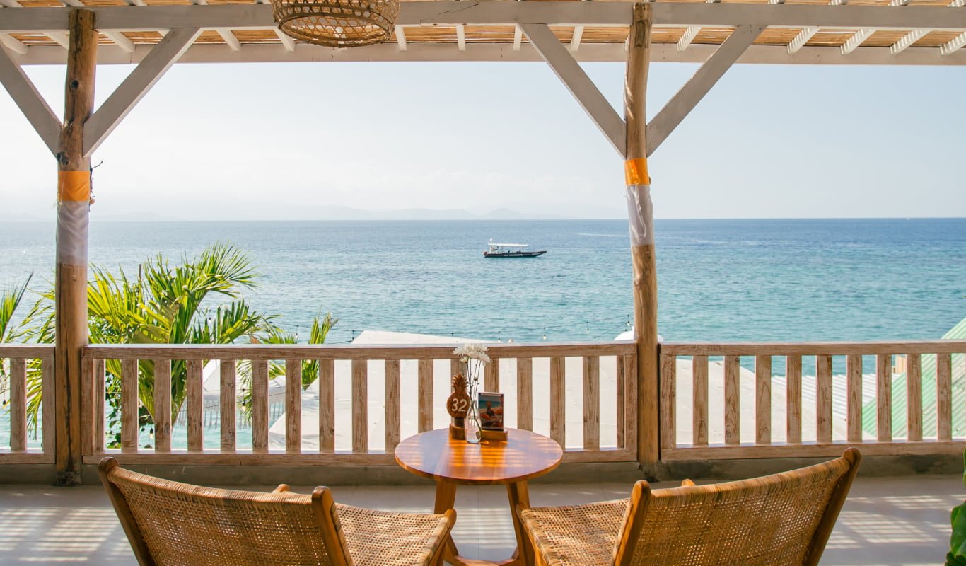 Table for two on the upstairs terrace facing the turquoise water at Penida Colada, Nusa Penida, Bali