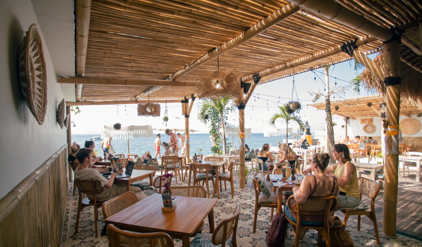Bamboo-framed dining area looking onto the beach at Penida Colada, Nusa Penida, Bali