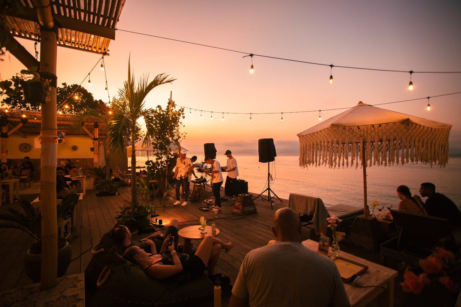 Live band playing on the beachfront deck at sunset at Penida Colada, Nusa Penida, Bali