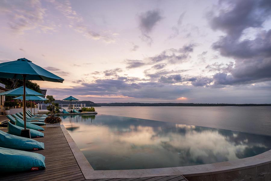 Main infinity pool at sunset over the Toyapakeh strait at Pramana Natura Nusa Penida, Bali