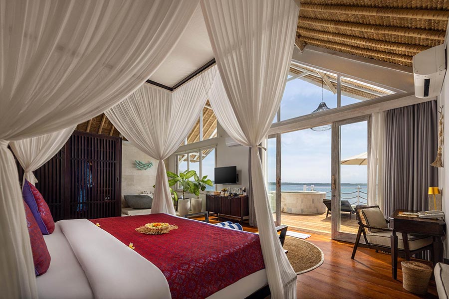 Royal pool villa bedroom with a canopy bed and ocean-facing terrace at Pramana Natura Nusa Penida, Bali