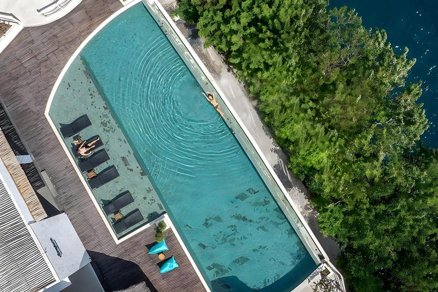 Aerial view of the long cliffside pool and timber deck at Pramana Natura Nusa Penida, Bali