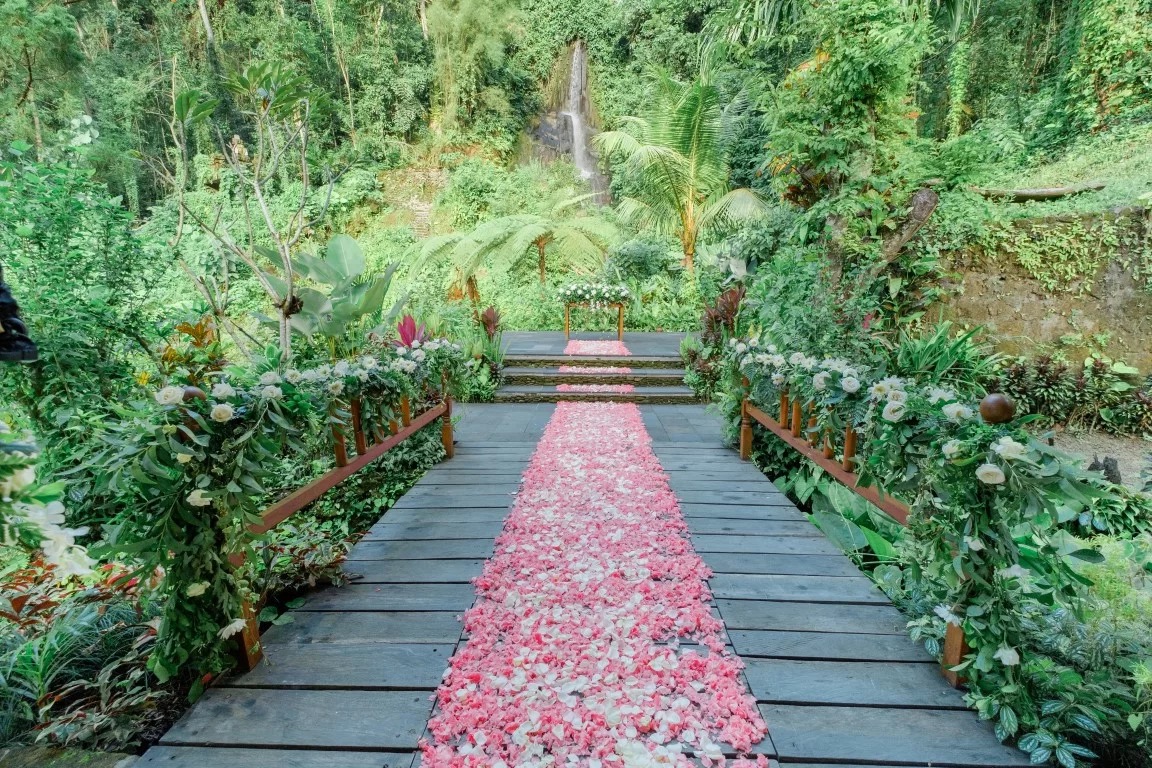 Outdoor walkway with pink flower petals and lush jungle surroundings at The Royal Pita Maha wedding venue
