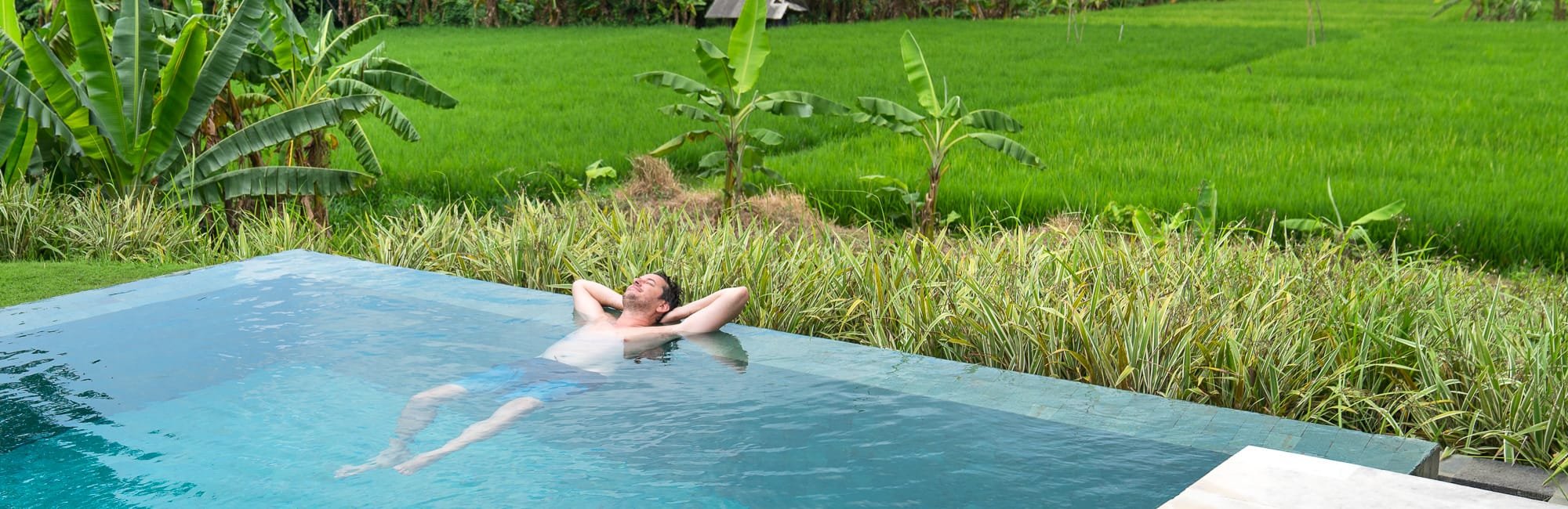 The Samata's infinity pool looking out over bright green rice fields near Sanur