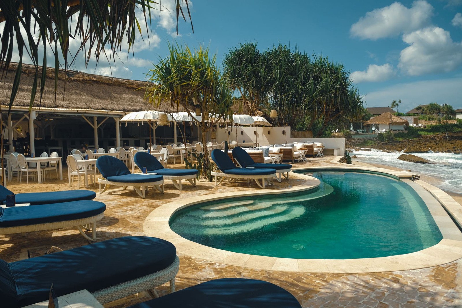 Beachfront pool and blue daybeds looking out to the headland at Sandy Bay Beach Club, Nusa Lembongan, Bali
