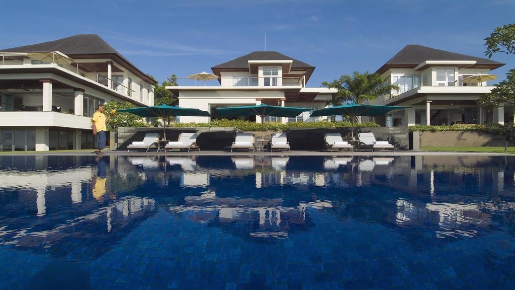 Reflecting pool and garden pavilions at Sanur Residence in Sanur, Bali, with lounge chairs and shade umbrellas