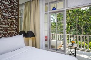 Traditional Indonesian-style guest pavilions among tropical gardens at Segara Village