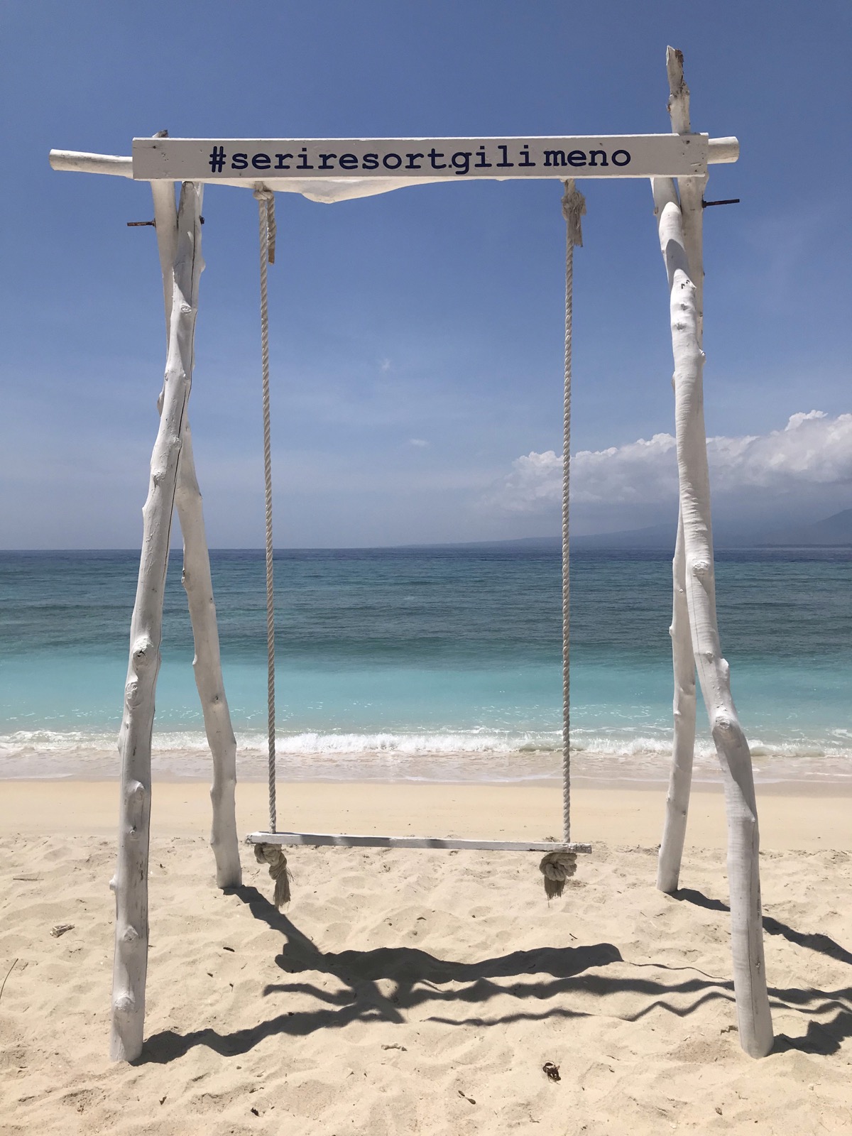 Driftwood swing on the white sand facing the sea at Seri Resort Gili Meno