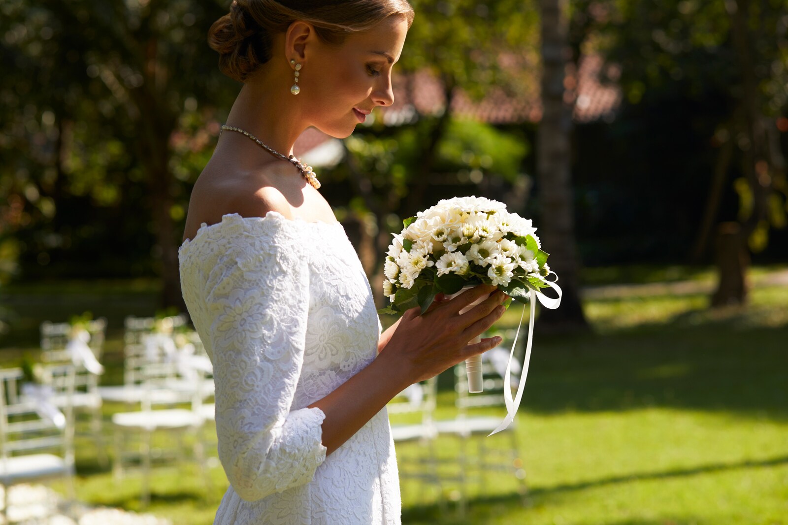 Bride holding a white bouquet beside the ceremony chairs in the garden at Sheraton Senggigi Beach Resort, Lombok
