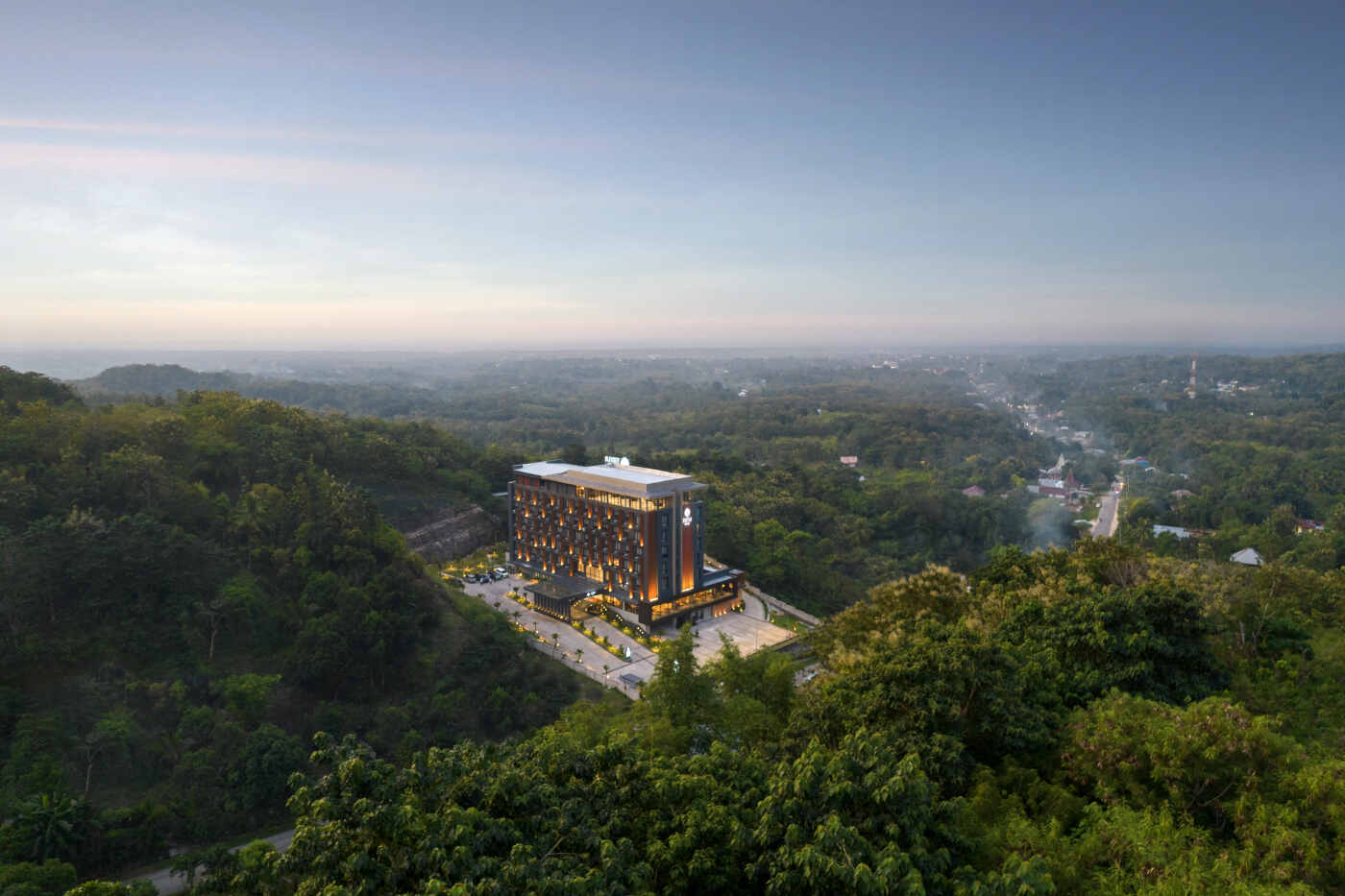 Aerial view at dusk of Sima Hotel Sumba standing above the forest on the edge of Tambolaka, Sumba