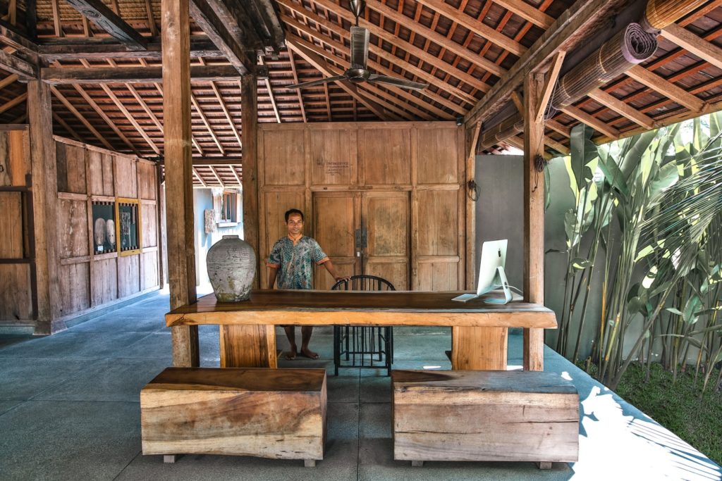 Open timber reception pavilion with a live-edge desk at Slow Private Pool Villas, Gili Air