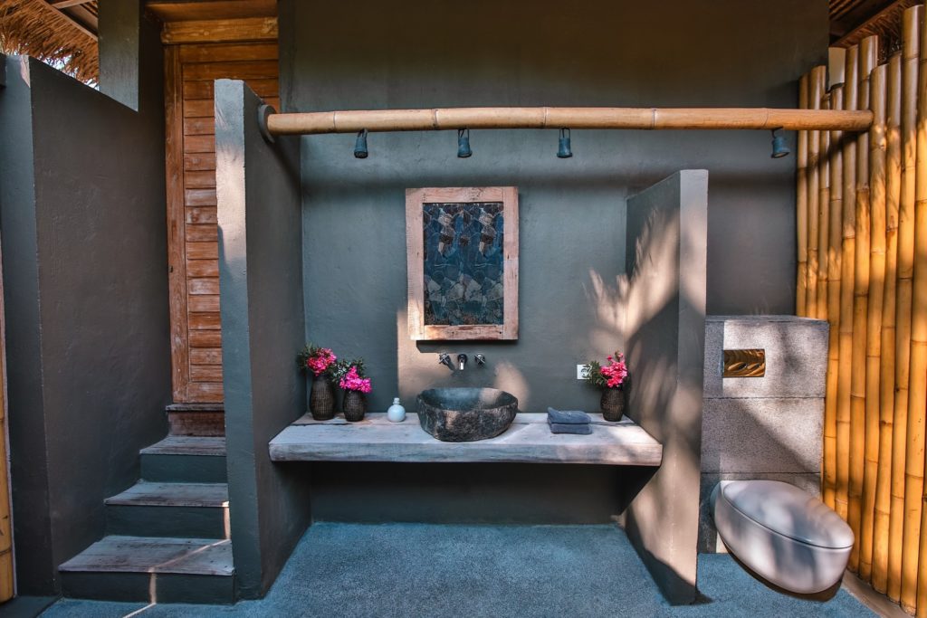 Open-air bathroom with a stone basin and bamboo screen at Slow Private Pool Villas, Gili Air