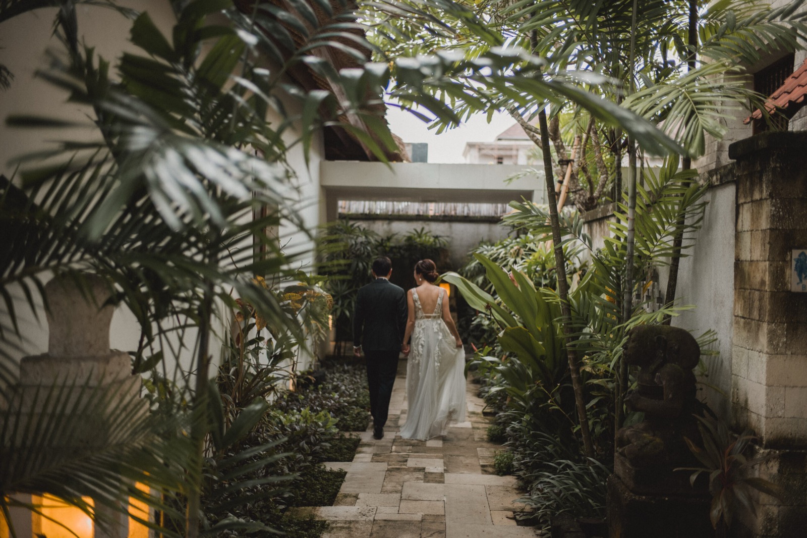 Bride and groom walking a stone path through the tropical gardens at Sudamala Resort, Senggigi, Lombok