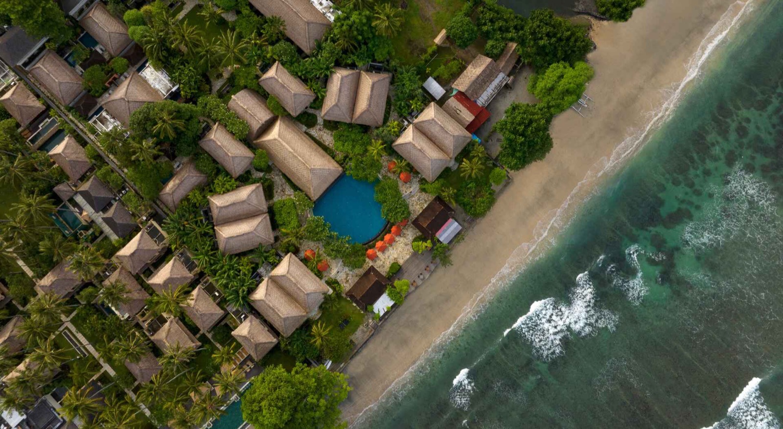 Aerial view of the thatched bungalows, pool and beachfront of Sudamala Resort, Senggigi on Lombok