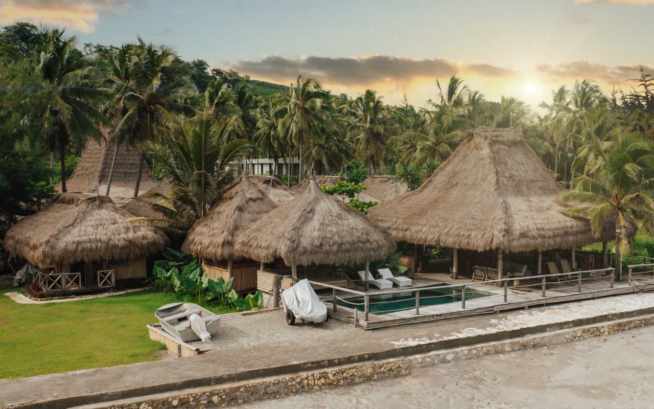 Thatched peaked-roof pavilions and pool set just back from the sand at Sumba Beach House on Sumba, one flight from Bali