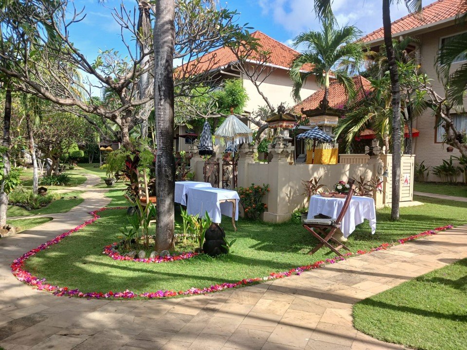 Garden ceremony set up with a petal outline on the lawn and a Balinese shrine behind at Tauch Terminal Resort Tulamben & Spa in northeast Bali