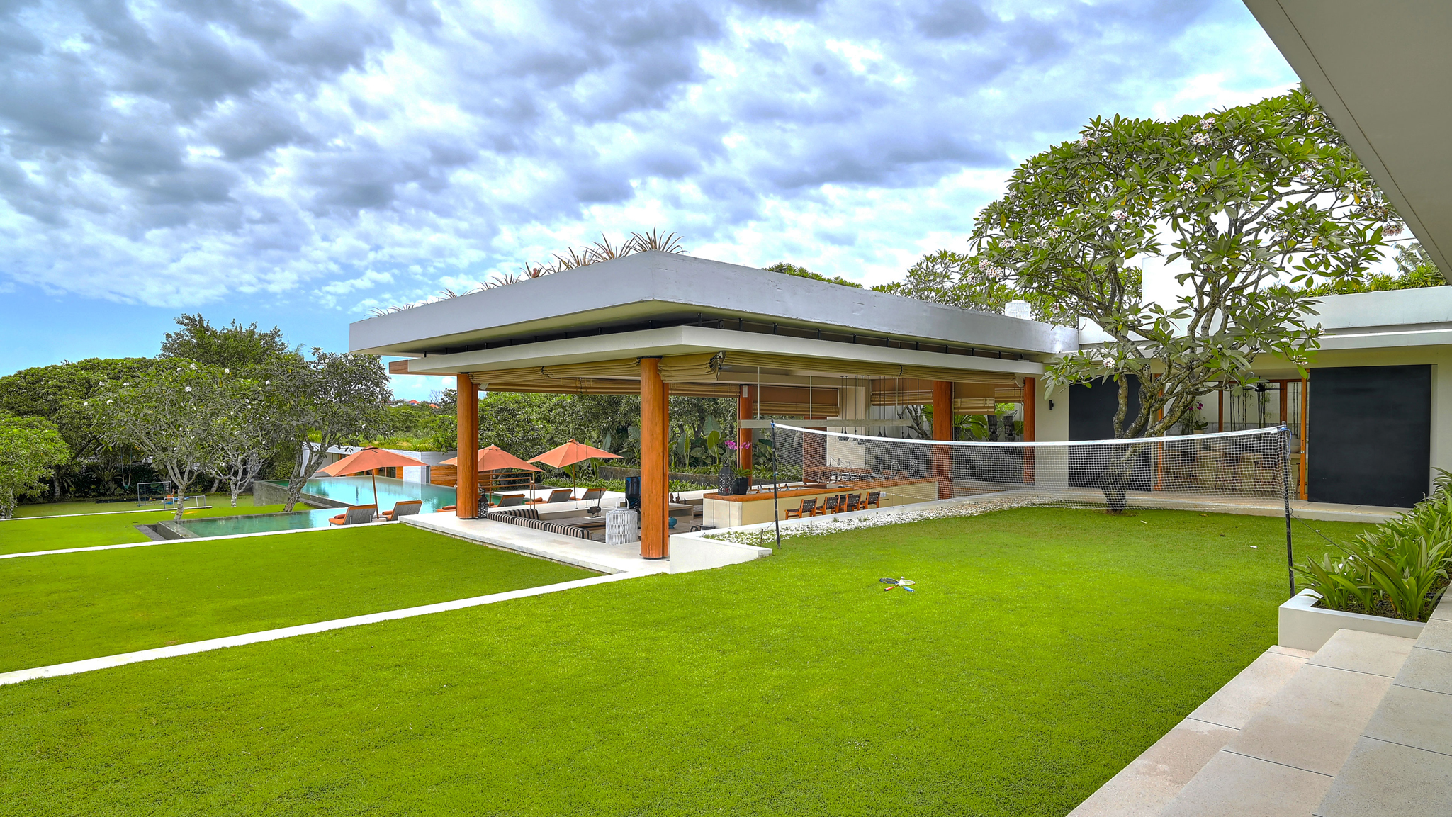 Wide lawn and gardens at The Iman Villa, framed by rice terraces in Pererenan, Canggu
