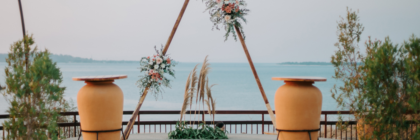 Wedding arch dressed with peach florals framing the water on the hilltop deck at The Kayana Beach Lombok