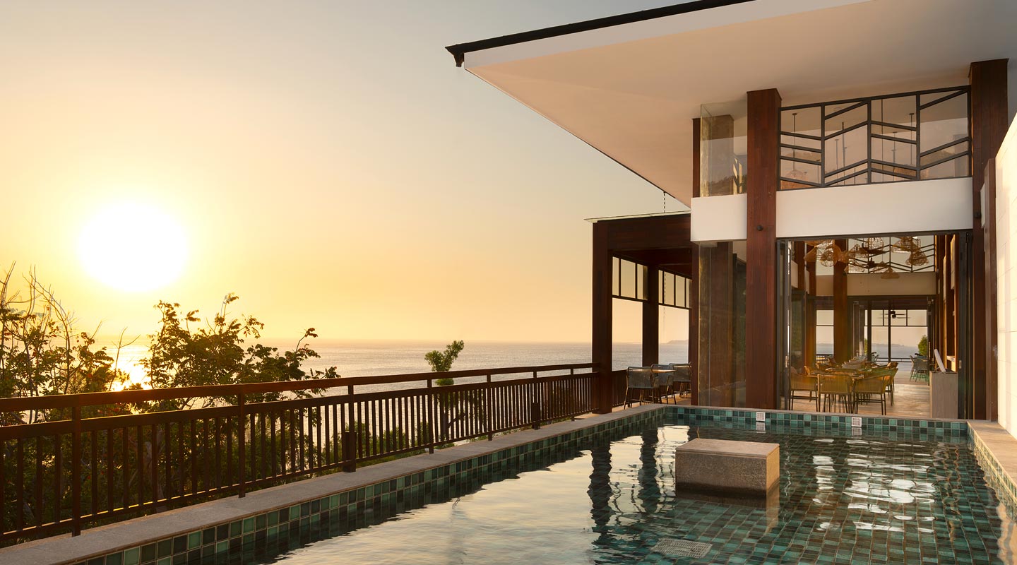 Pool and open restaurant pavilion facing the sunset at The Kayana Beach Lombok on Lombok's northwest coast