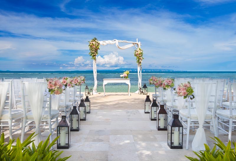 A beachfront wedding setup on the white sand at The Laguna Resort in Nusa Dua, with an arch facing the Indian Ocean