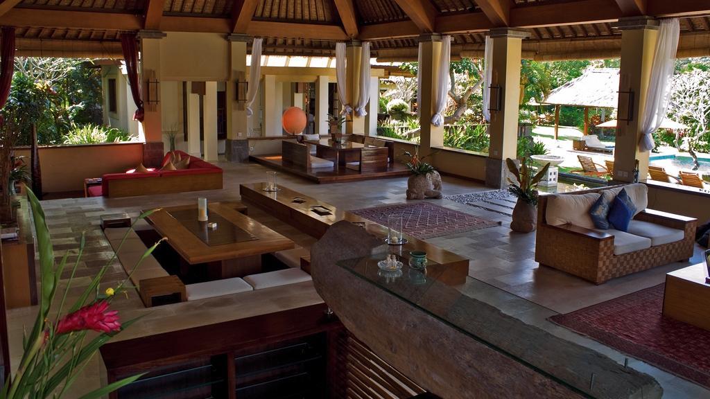 Open-air lounge pavilion interior at The Lotus Residence, with views out to the garden and pool