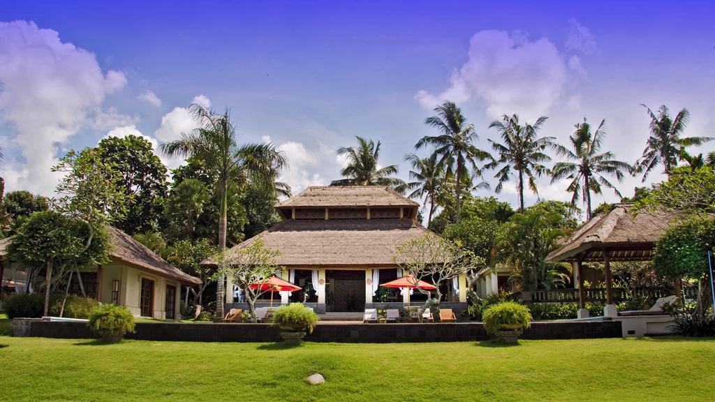The Lotus Residence entrance pavilion and front lawn, shaded by palm trees