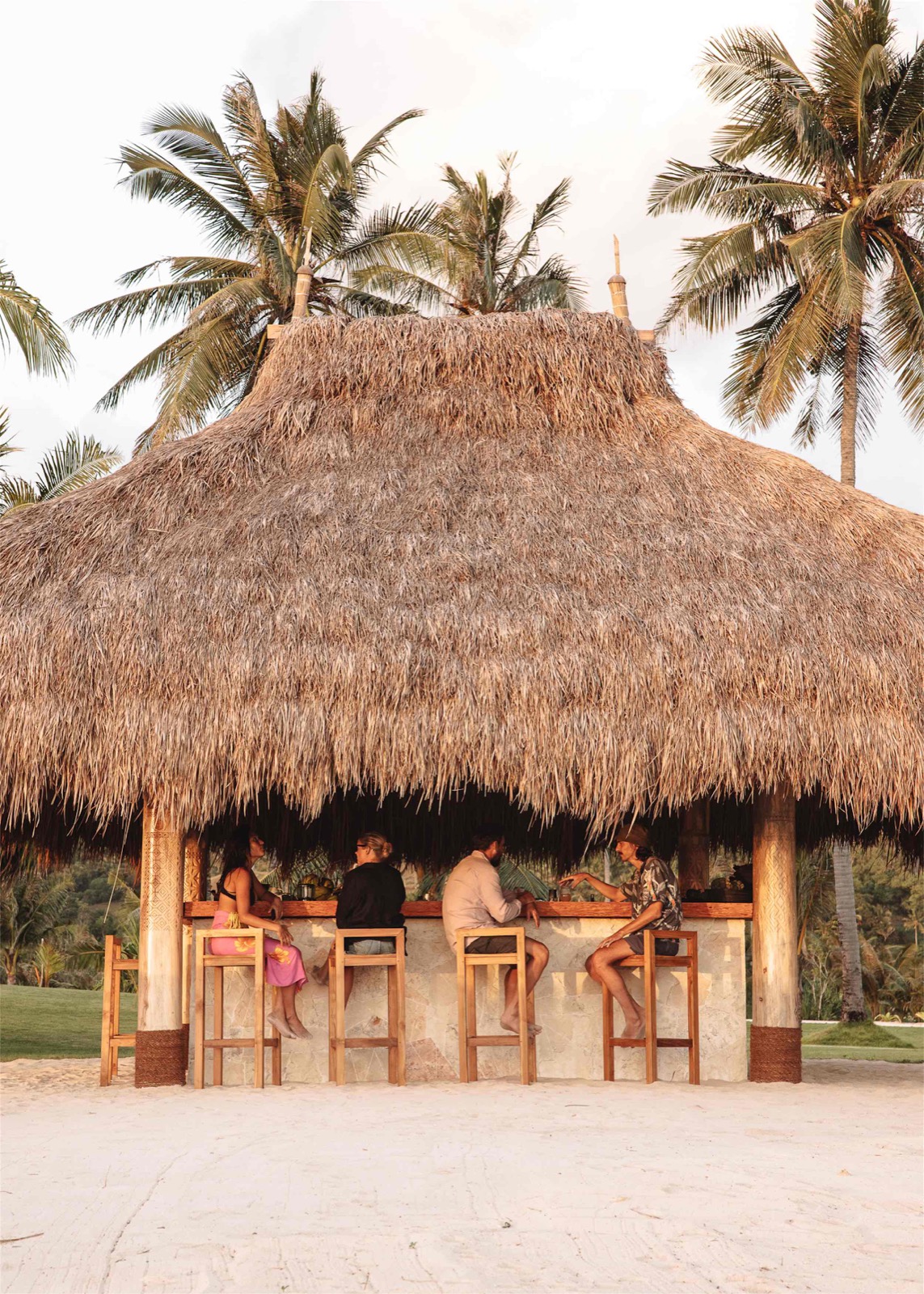 Guests at the thatched beach bar on the sand at The Sanubari, Sumba