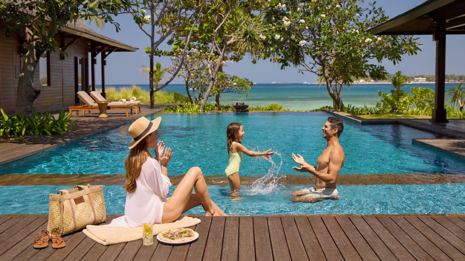 Family playing in the pool at the water's edge at The Sira, a Luxury Collection Resort and Spa, Lombok