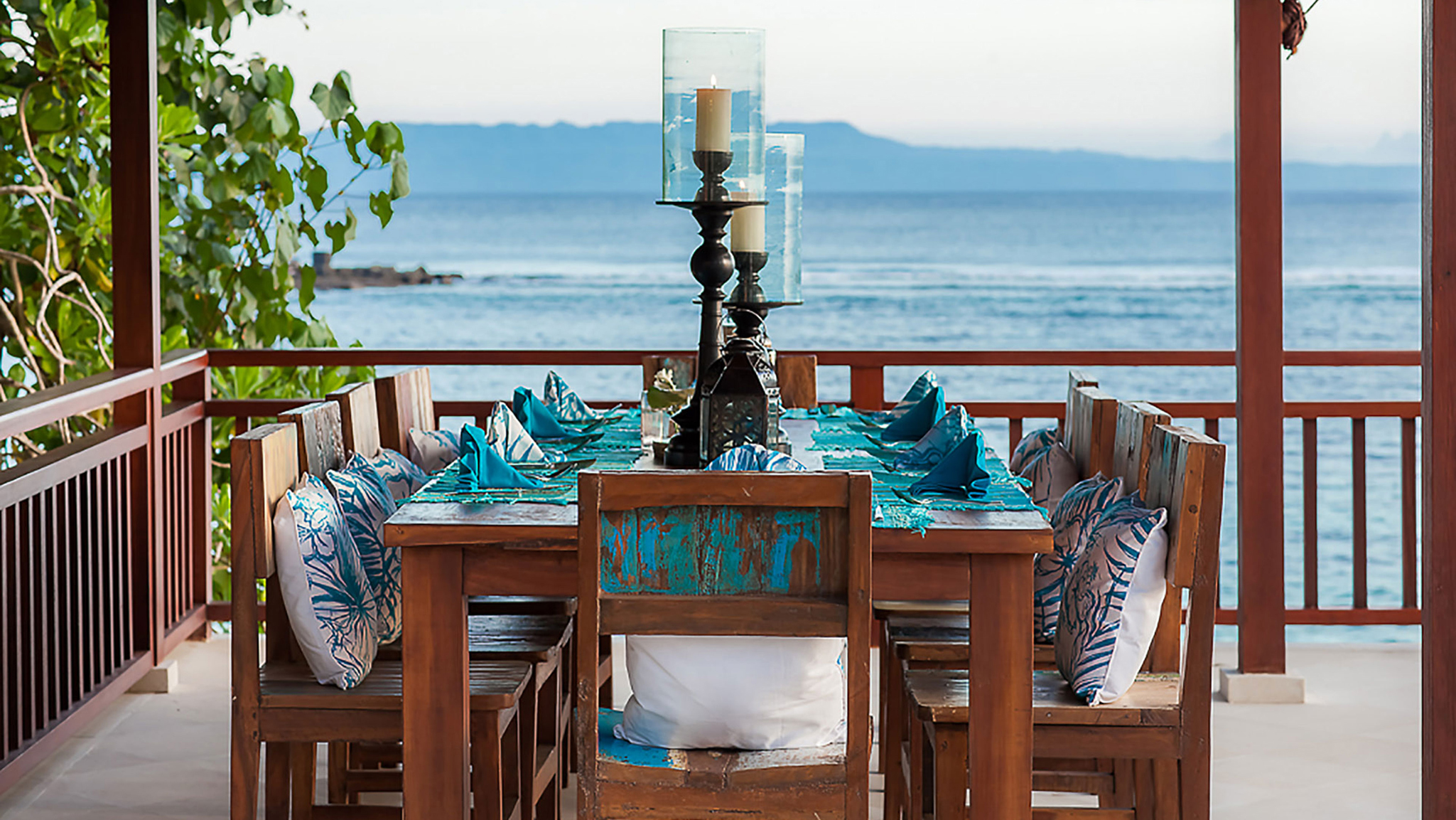 Romantic oceanfront dining table at Tirta Nila decorated for an intimate dinner with ocean backdrop